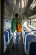 © DimaBerlin - Man traveler steps into car of electric train, ready for journey ahead, back view. Male with bag in empty car, travel by public transport, commuter lifestyle, adventure by rail, solo journey