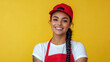 © Александр Марченко - Young smiling waitress wearing red apron and cap posing on yellow background