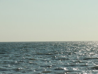 sea ​​view of calm cold sunny waters and empty horizon under bright sky, sea water background photo with empty space