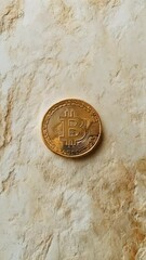 Poster - Single, gleaming golden bitcoin rests on a textured, off white surface, symbolizing investment in cryptocurrency and the future of finance