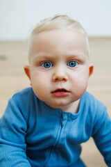 Wall Mural - Little one-year-old boy with different emotions on his face close-up. Emotional baby. Cheerful boy. Blue-eyed toddler boy.