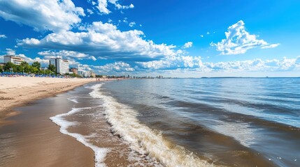 Wall Mural - Coastal Scenery with Beachfront City Skyline, Calm Waters and Blue Sky with Clouds