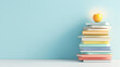 © Andżelika - A stack of colorful textbooks arranged neatly on a white surface, with a glowing apple placed on top.
