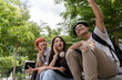 © amnaj - Three asian students taking a selfie sitting on stairs in a park, enjoying their free time