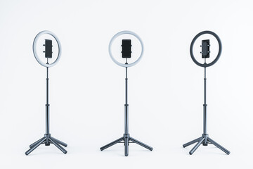 Poster - Adjustable ring lights with smartphone holders on tripods, isolated on a light background. 3D Rendering