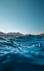 Wall Mural - Underwater view of serene ocean waves with distant mountains.