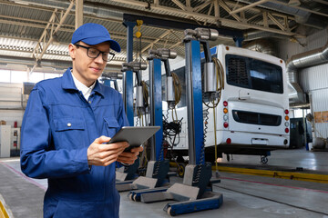 Poster - Serviceman with digital tablet on the background of the truck in the car service.