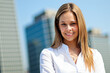 © Minerva Studio - Businesswoman smiling with buildings in background