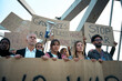 © CarlosBarquero - Multiracial and diverse ages group of activists gathered shouting at a demonstration. Angry people protesting at an anti-war march holding written banners with messages in the street in the city