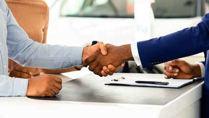 Wall Mural - Buying New Car. African American Couple Shaking Hands With Salesman In Dealership Center, Happy Black Spouses Purchasing Family Vehicle In Automobile Showroom, Signing Papers In Salon, Free Space