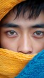 © Vagner Castro - Portrait of a young Asian queer transgender man under the colorful flag. Close-up of sad look hiding true LGBT identity.