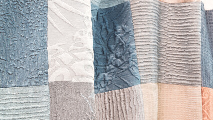 Poster - A collection of different colored fabric pieces are displayed in a row. The colors include blue, gray, and white. The arrangement of the pieces creates a sense of texture and depth