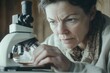 © Anjali - A focused woman intently examines a sample under a microscope, her expression revealing concentration and perhaps concern.