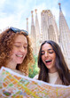 © CarlosBarquero - Vertical. Young only women friend looking travel map in hands in front of Sagrada Familia in Barcelona. Beautiful caucasian girls at European city enjoying vacation happy and smiling. Tourism people