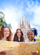 © CarlosBarquero - Vertical. Young only women friend looking travel map in hands in front of Sagrada Familia, Barcelona. Beautiful diverse girl at European city enjoying vacation happy and smiling. Funny tourism people