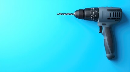 Poster - A drill placed vertically with its bit pointing downwards, on a solid blue background.