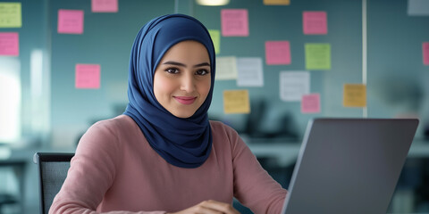 Aufkleber - Smiling muslim businesswoman working on laptop in modern office with sticky notes