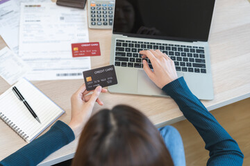 Internet banking, Online shopping at home, asian young woman hand in typing on keyboard, holding credit card, using laptop computer, spending money with purchase on store at home. Shopaholic ecommerce