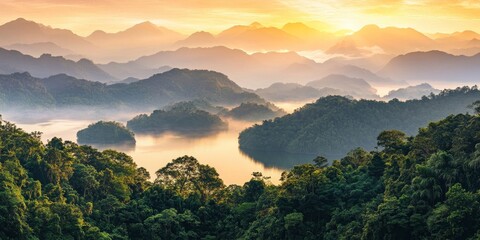 Wall Mural - Sunrise over misty mountains and lake.