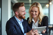 © Amir Bajric - Business colleagues sharing a laugh over a tablet. Male executive and young female employee