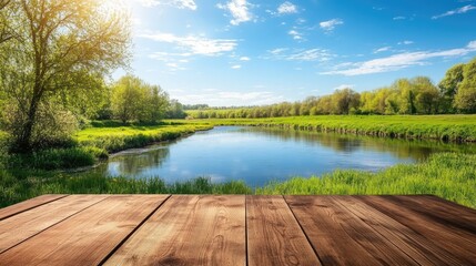 Poster - Empty wooden table outdoors in a beautiful spring landscape, with a lush green field and a clear river reflecting the blue sky, perfect for showcasing nature.