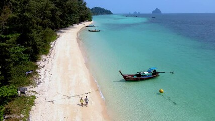 Wall Mural - Stroll along the soft sands of Koh Kradan, feeling the warm sun and the gentle breeze. Discover the beauty of clear blue waters, lush greenery, and cozy boats dotting the shoreline.