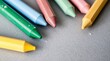© hyperbleh - Multicolored crayons arranged on a gray surface in close-up