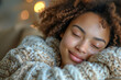 © photolas - A serene young woman with her eyes gently closed, as a contented smile graces her face, cozily resting on a soft pillow.