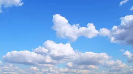 Wall Mural - Beautiful fluffy clouds drifting across a bright blue sky during a sunny afternoon in a peaceful outdoor setting. Calm and romantic background with clouds on the weather theme.