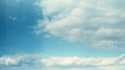 Wall Mural - Beautiful fluffy clouds drifting across a bright blue sky during a sunny afternoon in a peaceful outdoor setting. Calm and romantic background with clouds on the weather theme.