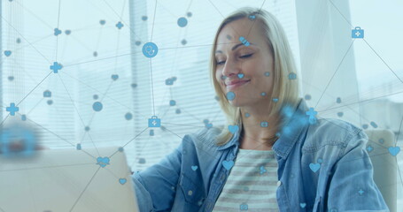 Poster - Image of network of connections with icons over caucasian woman using laptop