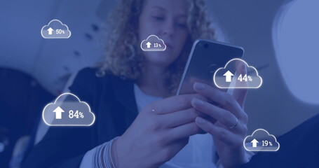 Poster - Image of clouds with percents and arrow over caucasian businesswoman using smartphone