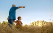 © Westend61 - Elderly man showing direction to grandson in agricultural field