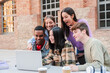 © Jose Calsina - Group of enthusiastic students gathered around a laptop, engaged in collaborative study session, sharing ideas and excitement, representing teamwork and learning among teenagers at university campus