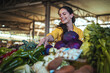 © Dragana Gordic - Smiling Woman Shopping for Fresh Produce at a Local Farmers Market