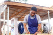 © wazkkii - cheerful young carpenter measuring and preparing materials for woodworking projects at an outdoor workshop. Perfect for themes related to craftsmanship, education, or artisanship.