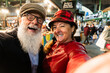 © DisobeyArt - Happy senior couple having fun together taking selfie at food market - Fashion wife and husband making a city tour in London - Travel and joyful elderly lifestyle concept - Focus on woman face