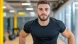 © aun - Young Male Athlete Posing in Modern Gym Setting with Bright Lighting