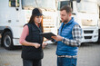 © Serhii - The truck driver receives documents for the cargo and the delivery route
