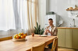 © LIGHTFIELD STUDIOS - A young man enjoys a peaceful moment in his modern apartment while relaxing with food and a phone.