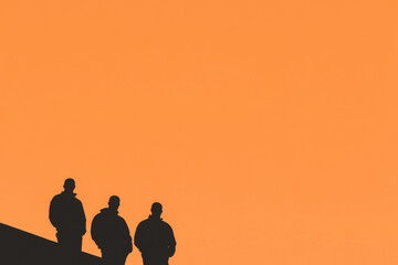 Wall Mural - Three men are standing on a roof, silhouetted against a bright orange sky