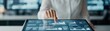 © Preeyanuch - A professional analyzing data on a touchscreen interface in a modern office setting, showcasing technology and innovation.