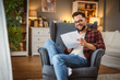 © Miljan Živković - adult happy man sit in the armchair read document with a good news