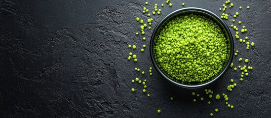 Wall Mural - Vibrant Green Bubble Seasoning in Black Bowl on Dark Textured Background with Fresh Green Spices and Empty Space for Textual Overlay