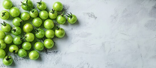 Wall Mural - Fresh Green Cherry Tomatoes on Light Gray Surface with Copy Space for Text, Emphasizing Healthy Eating and Vibrant Produce Aesthetic