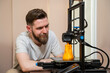 © phoenix021 - Man looking from close distance how his 3d printer works in his home