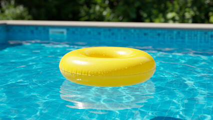 Poster - yellow swimming pool ring float in blue water. concept color summer