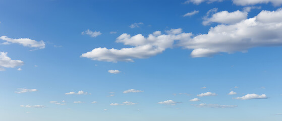 Wall Mural - expansive blue sky dotted with cotton - like clouds, warm light