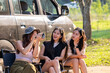 © Wasana - Three women sitting in a car, one of them taking a picture with a cell phone