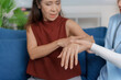 © amnaj - Female doctor examining hand of senior woman with wrist pain, healthcare and medical concept
